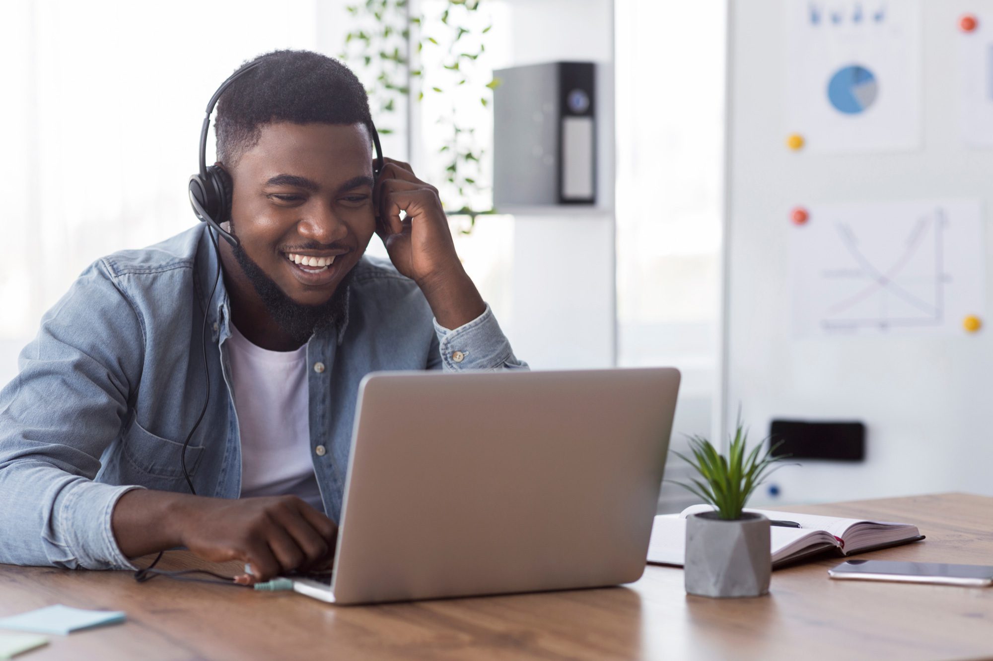 smiling man wearing headset and looing at a computer. university of dubuque online masters in business administration 